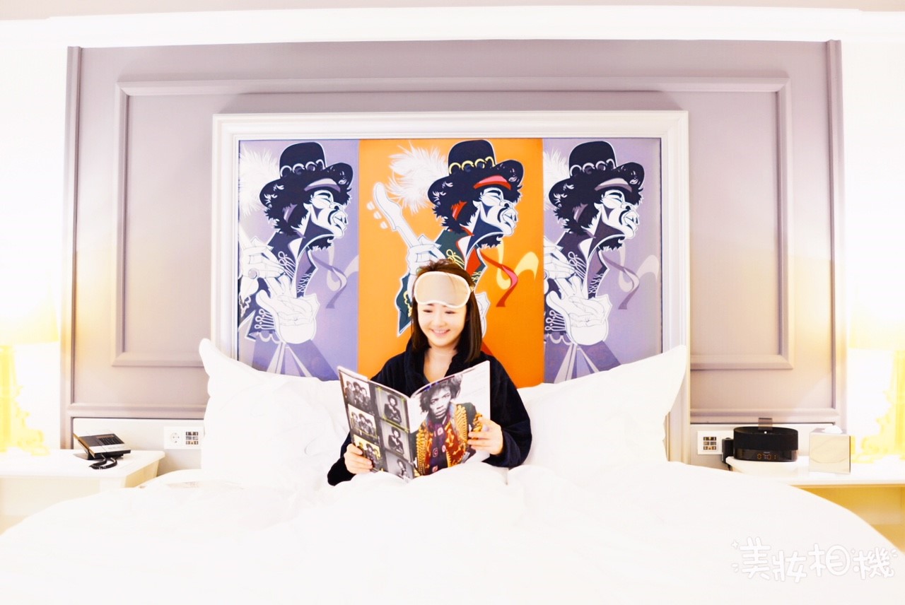 girl in bed with eye mask on reading a book